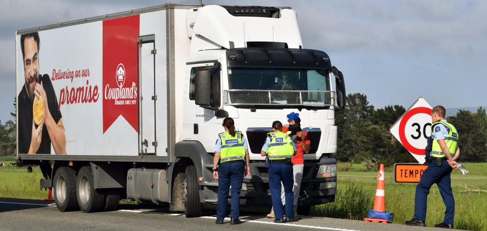 Police speak to a truck driver who was allegedly assaulted and had his truck damaged in an road...