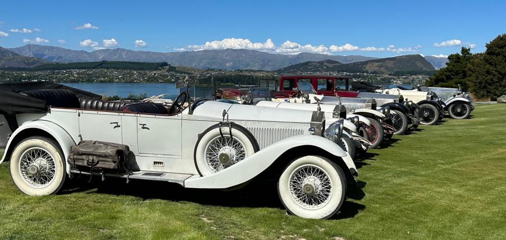 Six Rolls Royce Silver Ghost cars line up in front of the Wānaka township at Allan Dippie's Ruby...