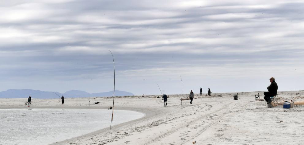 Fishermen line the Taieri River mouth.
