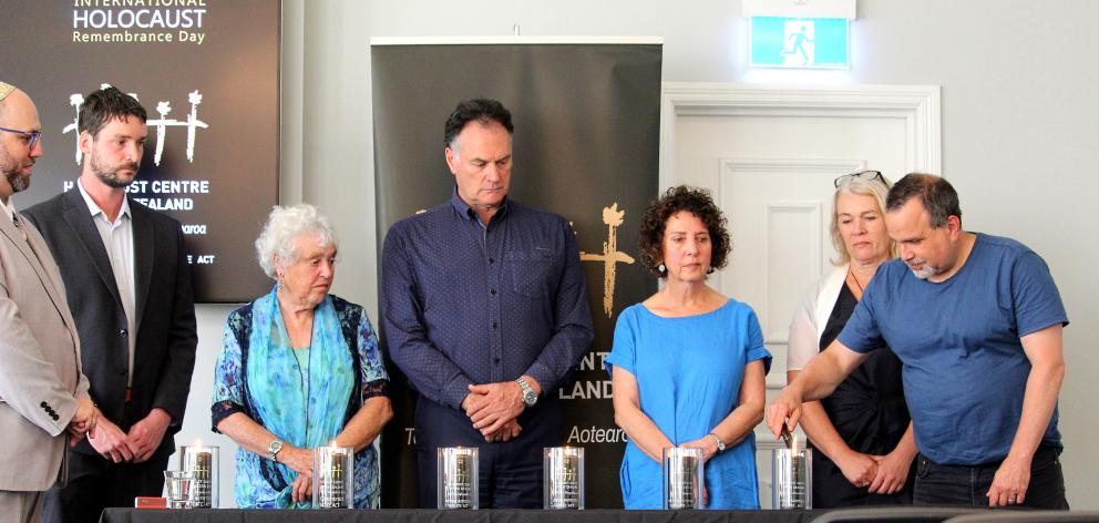 Lighting a candle in honour of the victims of the Nazis and their collaborators are (from left)...