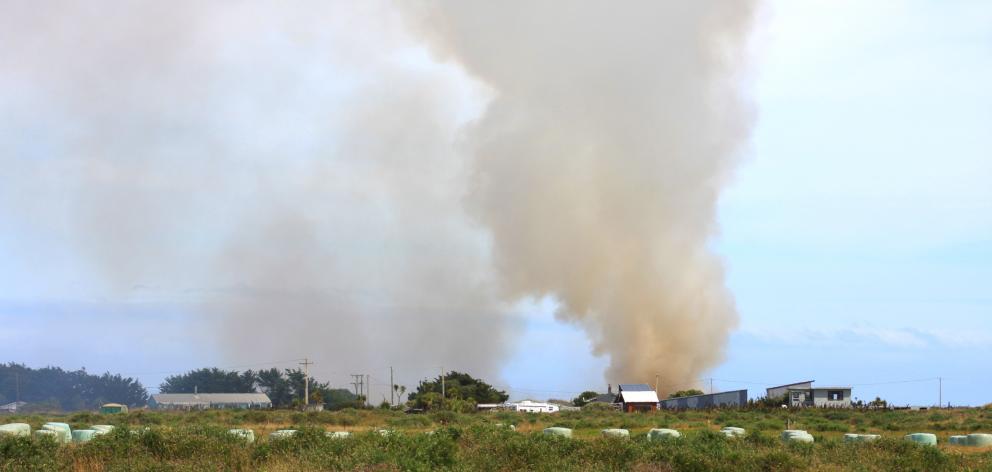Smoke from a car fire at Oreti Beach  spreads across Invercargill yesterday. PHOTOS: TONI...