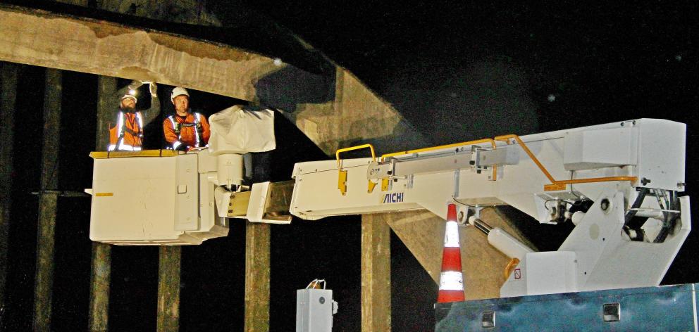 Crews work on separate hydraulic platforms during recent maintenance work on Balclutha bridge....