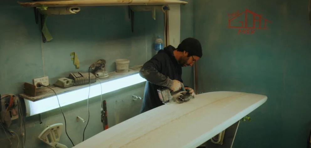 Co-founder Lucas Sampaio works on a donated surfboard. Photo: Supplied