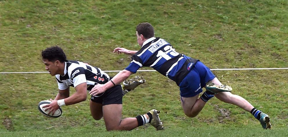 Southern loose forward Konrad Toleafoa scores a try in front of Kaikorai defender Troy Anstiss at...