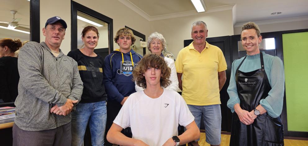 Friends and family gathering around Flynn Brookland as he prepares to lose his locks are (from...