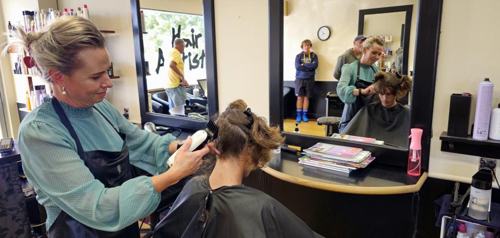 Nicole Austin, of Hair Artistry Timaru, begins the job of shaving off Flynn’s hair.