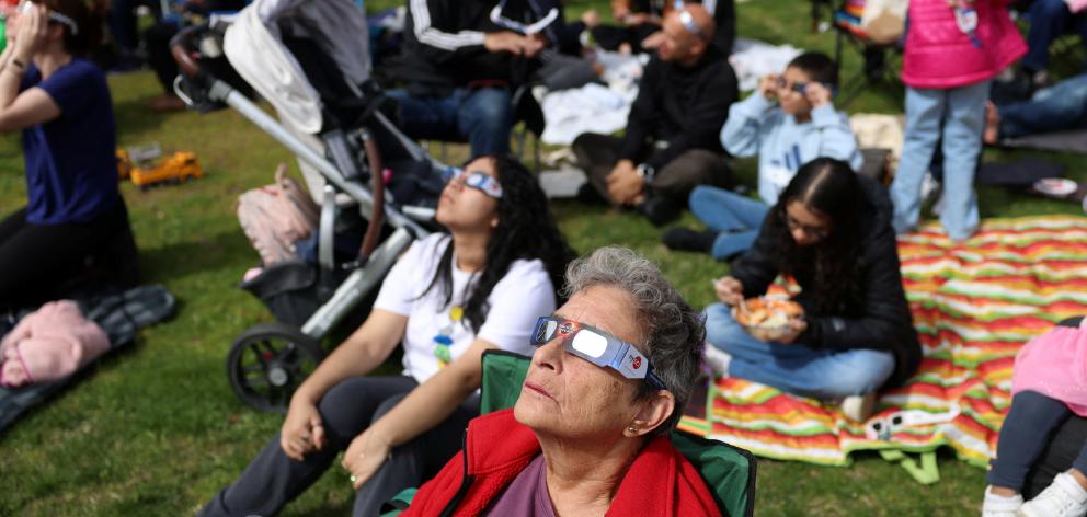 People view a partial solar eclipse at New York Hall of Science in Queens borough, New York City....