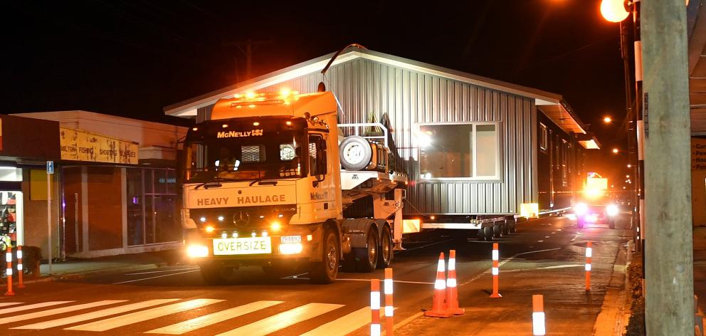 A 9m-wide transportable home built by Big River Homes takes up all the road as it is hauled...