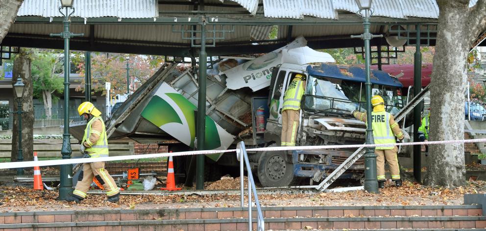Firefighters assess the situation after a truck crashed in the Octagon, Dunedin, on Saturday...