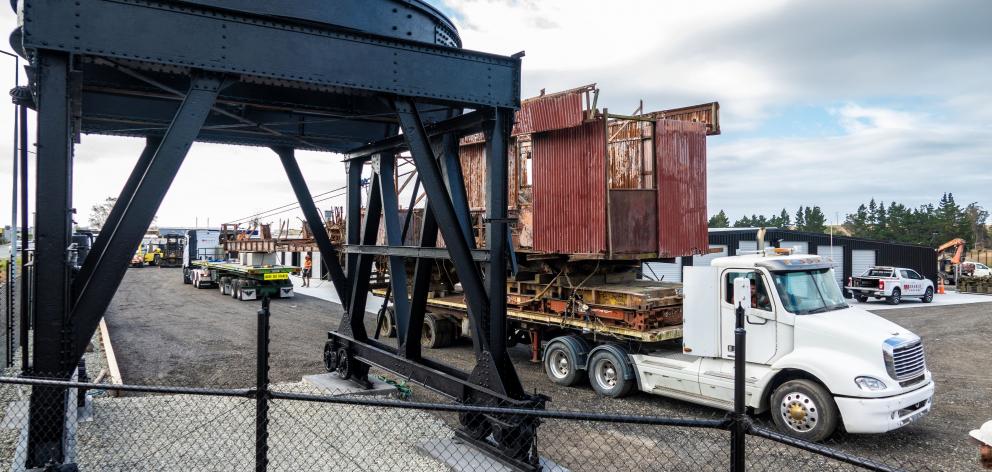 The crane body is transported past the newly restored frame it would have sat on top of when in...