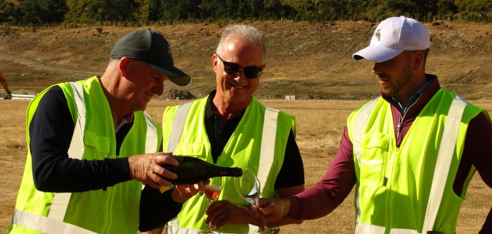 Watched by Gibbston Valley Resort CEO Greg Hunt, Sir John Key, left, pours bubbles for his son...