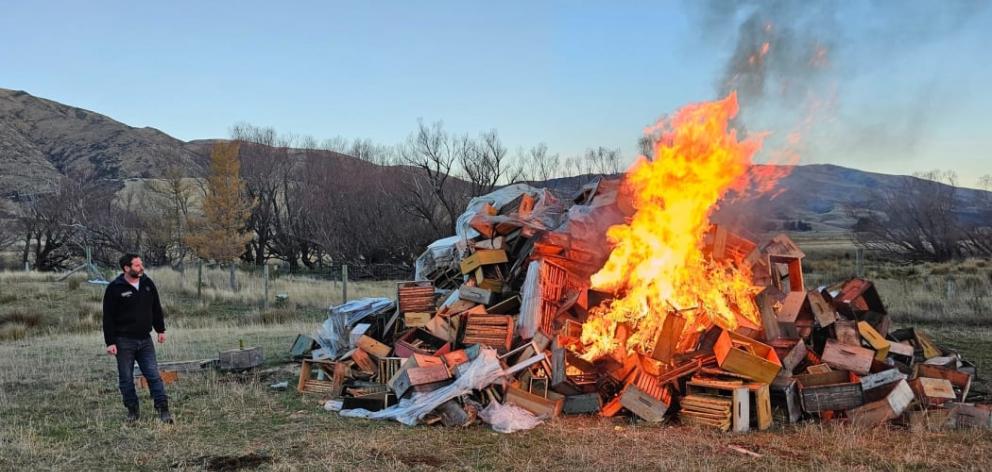 Steven Brown watches boxes of honey burn. Photo: Facebook / Steven Brown