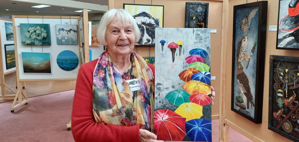 Holding her oil painting of umbrellas called It’s Raining Again is Norma Parks, of Tapanui. The...