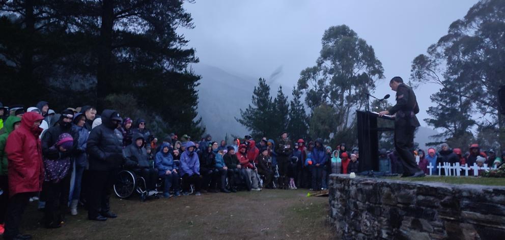 Under heavy rain and strong winds, attendees listen to Sergeant Lorne Capell speak at the Lake...