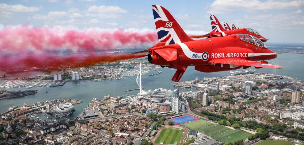 The RAF Red Arrows performed a flypast over Portsmouth in England. Photo: UK MOD via REUTERS
