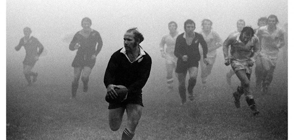 In a famous photo, Sid Going runs clear of the East Glamorgan defence in a 1970 tour game on a...