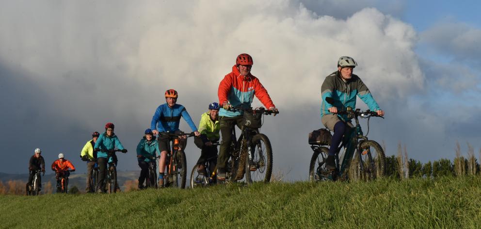 Colin Brown leads a group of cyclists along the Silver Stream floodbank near Mosgiel yesterday....