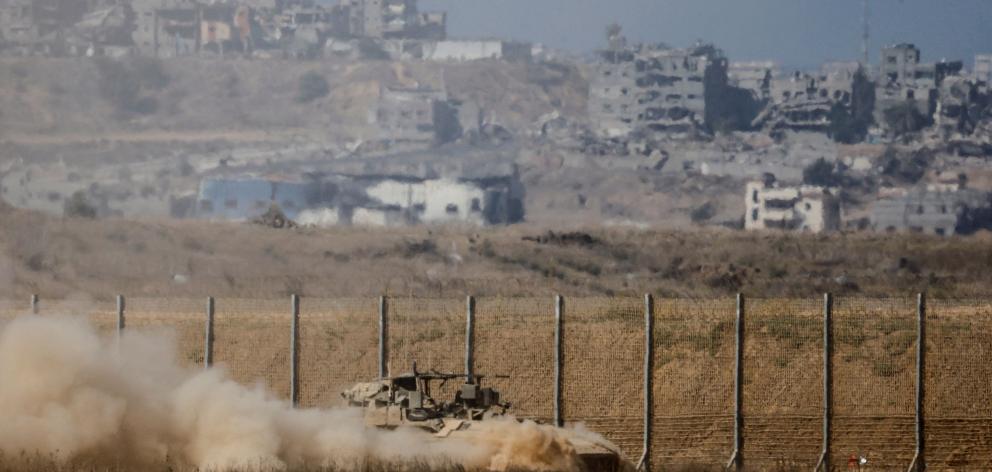 An Israeli armoured personnel carrier manoeuvres near the Israel-Gaza border. PHOTO: REUTERS