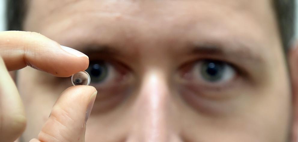 Dunedin Hospital eye surgeon Dr Francesc March holds one of the first intraocular lenses designed...