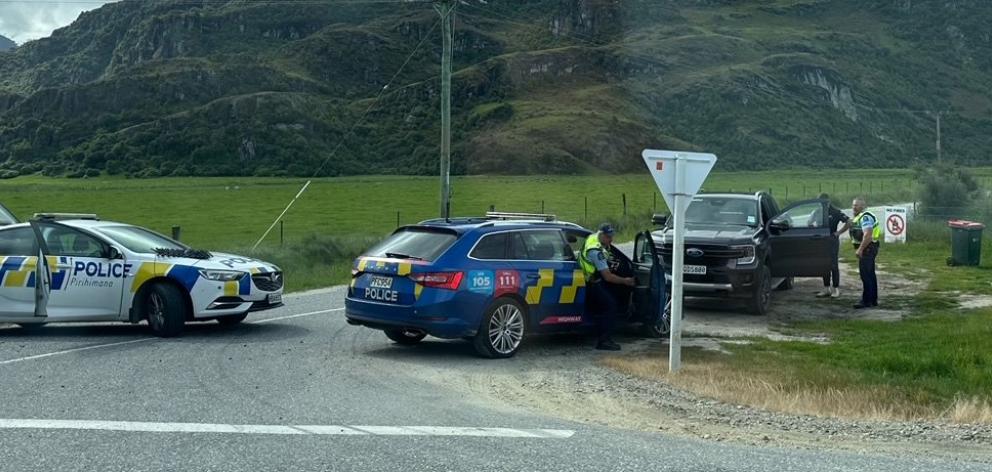 Police officers take a man into custody after he was stopped, allegedly for dangerous driving, in...