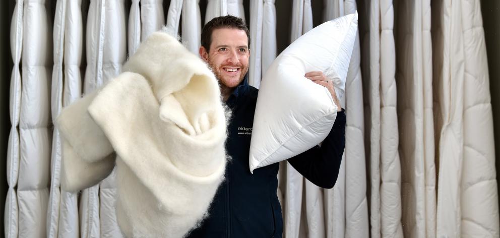 Eiderdown sales director Lucas Mills holds up fibre from an alpaca duvet and a Hungarian goose...