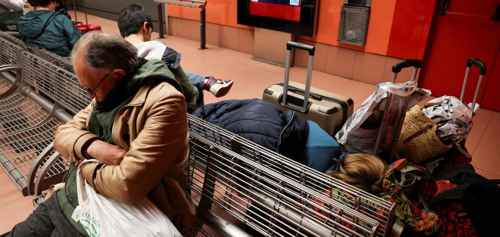 People waiting at a railway station in Madrid following the huge outage that hit Spain and...