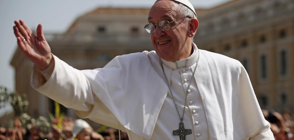 Pope Francis waves to the crowds during a drive around St. Peter's Square during Palm Sunday Mass...