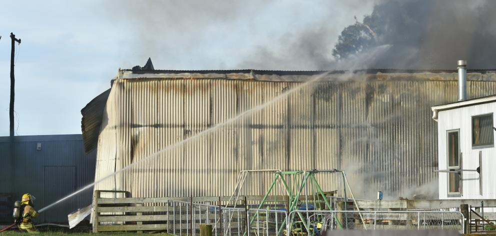 Firefighters are seen battling a large 30m by 30m fire in a farming shed on Bush Rd. PHOTO:...