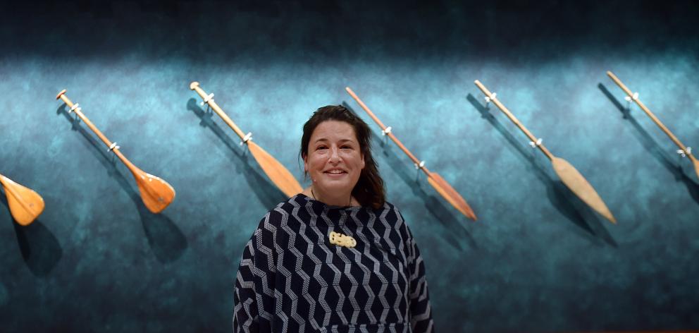 Hocken curator Māori Jacinta Beckwith with waka oars on display in the exhibition Hauteruruku ki...
