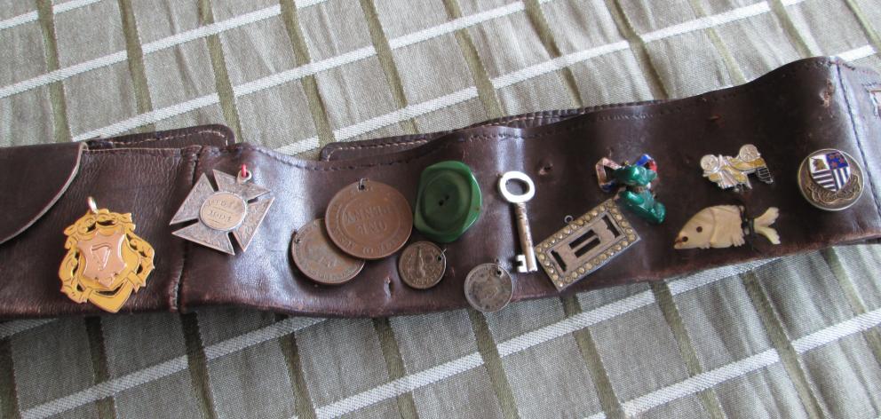 The mystery soldier’s army belt with the gold medal awarded to P. Dickel (far left) and next to...