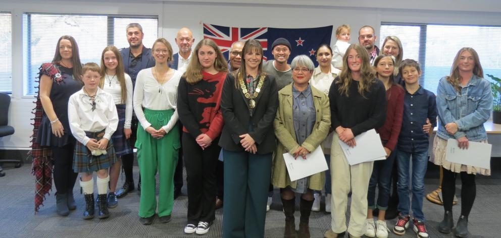 Seventeen newly-minted New Zealand citizens pose for a photo with Central Otago District Mayor...