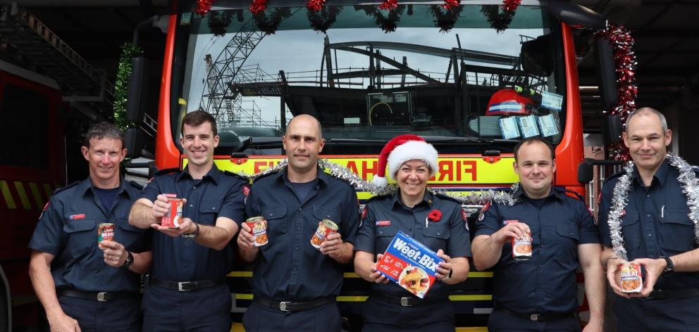 Organiser of the Combined Dunedin Foodbanks Christmas Can Collection Aimee Taylor (wearing the...