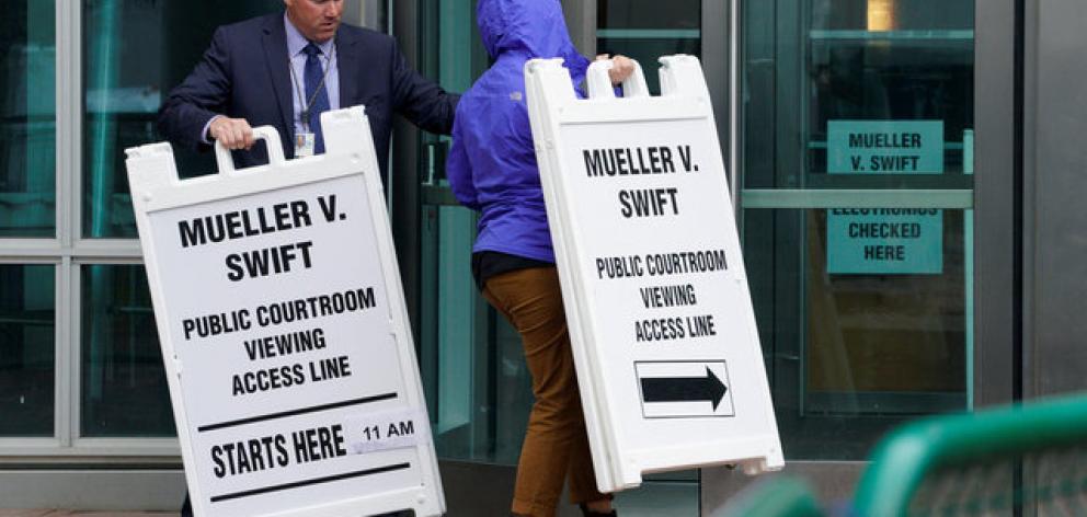 Workers take in signs from outside Denver Federal Court where the Taylor Swift groping trial jury selection begins in Denver. Photo: Reuters