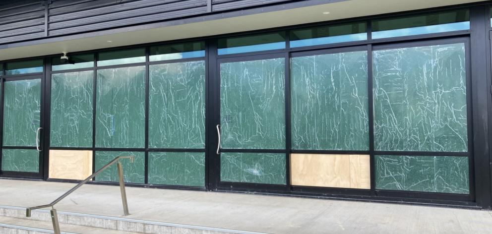The broken windows had been covered this morning. Photo: Geoff Sloan