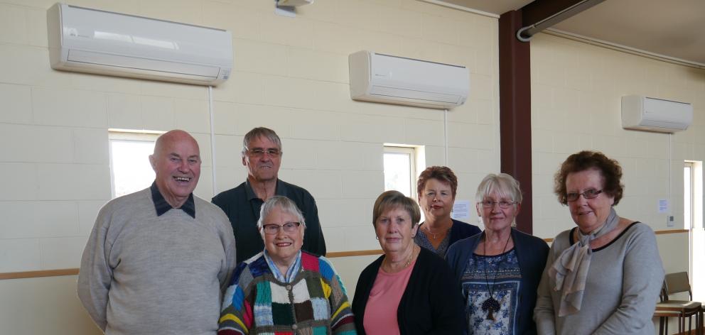Standing in front of the new heaters they recently bought for the Senior Citizens Hall are (back...