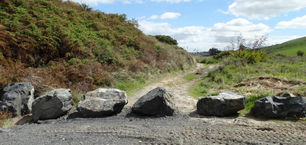 A row of large rocks, which the Department of Conservation has placed across the entrance to an...