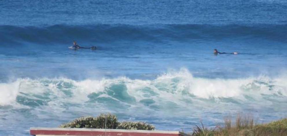 A couple of surfers had decided to head out on their boards this morning. Photo: Ken Cashin via...