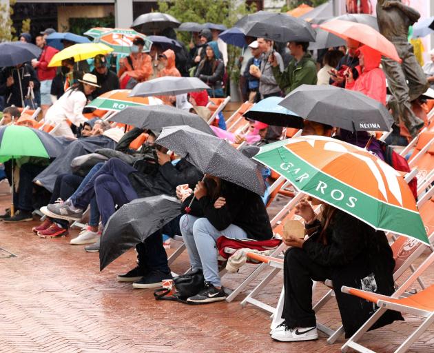 Spectators shelter from the rain during the second round. PHOTO: REUTERS