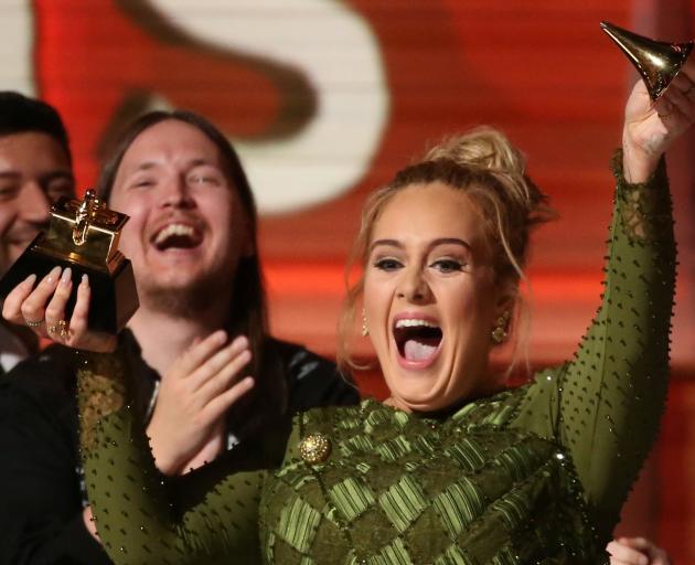 Adele celebrates after receiving the best record Grammy for Hello. Photo: Reuters 