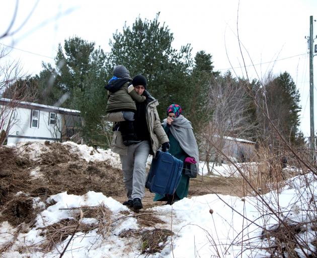 A family claiming to be from Turkey cross the US-Canada border into Quebec last month. Photo: Reuters 