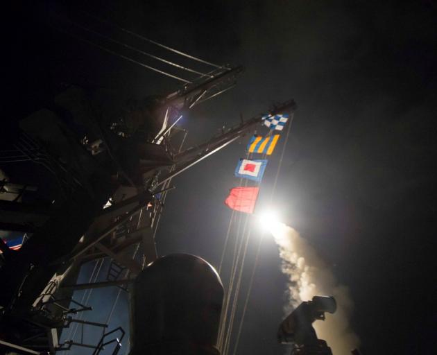 The US Navy guided-missile destroyer USS Ross fires a tomahawk missile from the Mediterranean Sea...