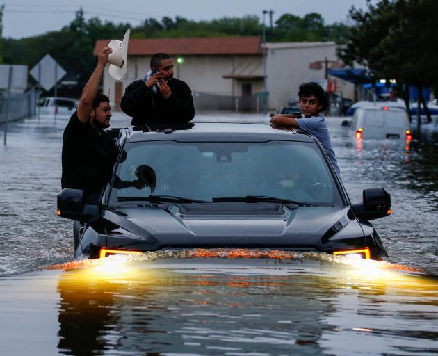 Residents in Houston, Texas, try to navigate through flood waters from Tropical Storm Harvey. Photo: Reuters 