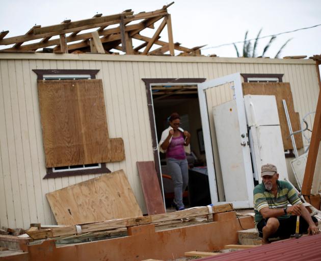 Julio Morales looks for valuables outside his damaged house after the area was hit by Hurricane...