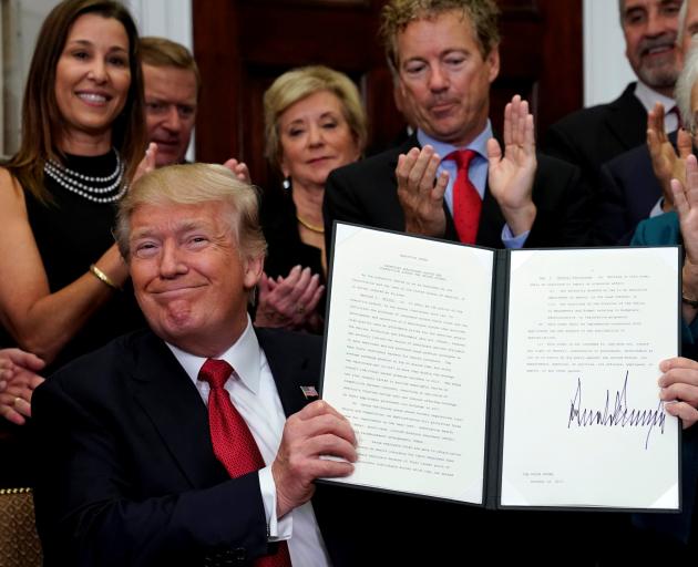 Donald Trump smiles after signing an Executive Order to make it easier for Americans to buy bare-bone health insurance plans and circumvent Obamacare rules. Photo: Reuters 
