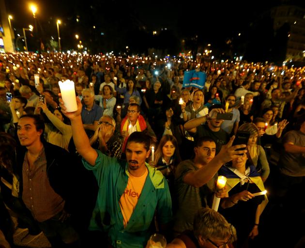 People hold candles during a gathering to protest against the imprisonment of leaders of two of...