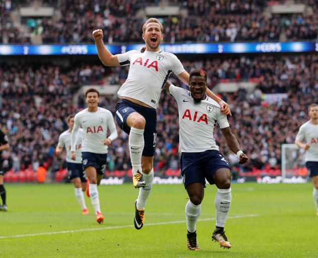 Tottenham's Harry Kane jumps in the air as he celebrates scoring their first goal with Serge...