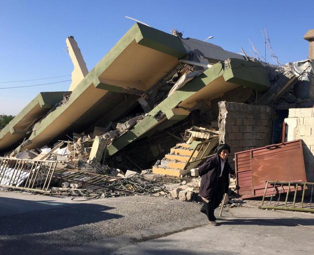 A man walks past a damaged building following an quake in Darbandikhan in northern Iraq. Photo:...