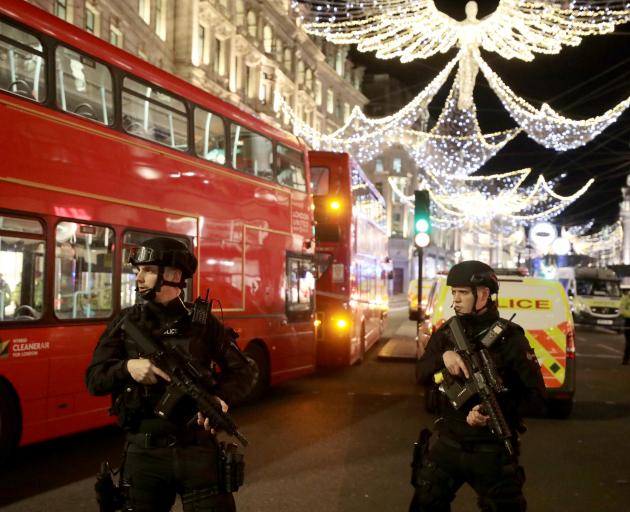 Armed police stand guard on Oxford St, one of London's busiest. Photo: Reuters