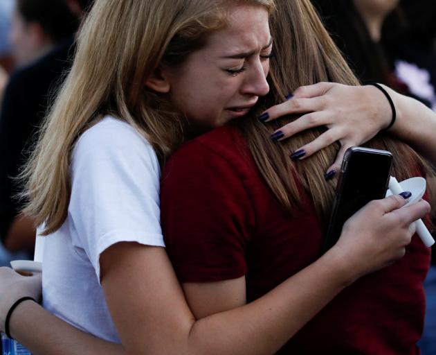 Students comfort each other at candlelight vigil for victims the shooting. Photo: Reuters 
