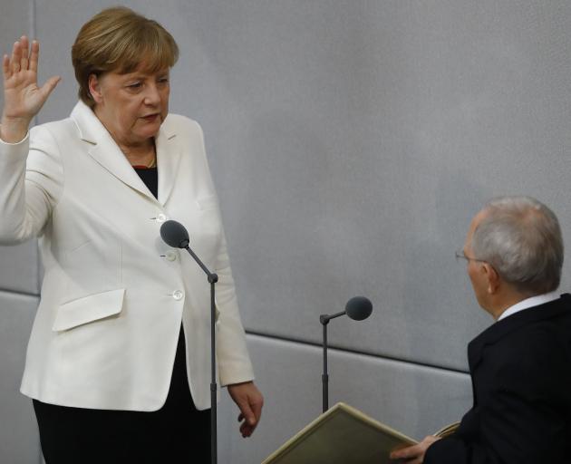 German Chancellor Angela Merkel is sworn-in by Parliament President Wolfgang Schaeuble on...